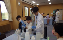 水質実験で顕微鏡をのぞく参加者