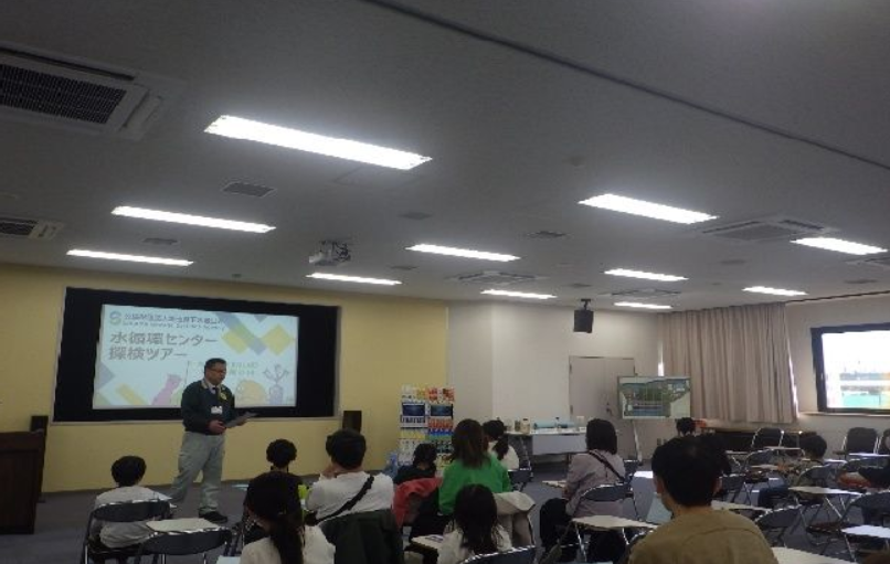 県民の日「水循環センター探検ツアー」の参加者に説明する様子