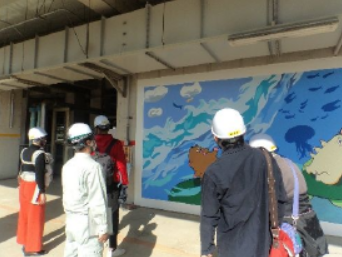 施設見学する親子２名と説明する職員